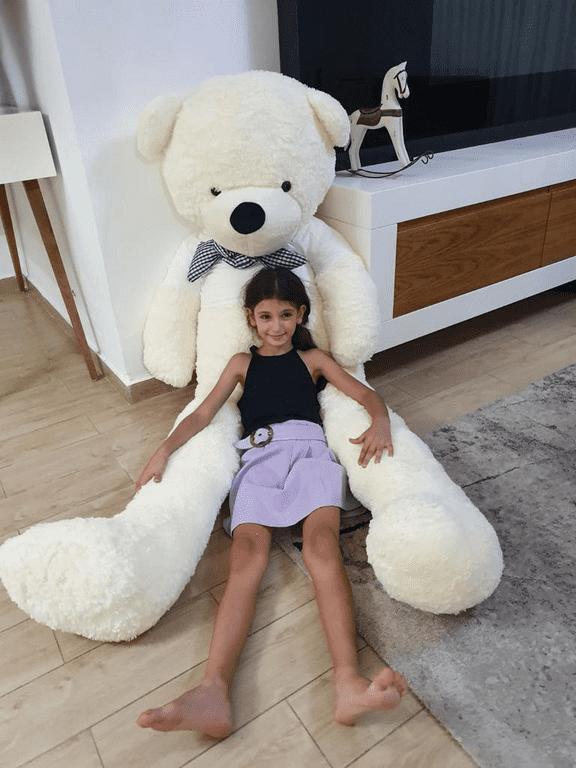 ילדה יושבת על דובי ענק שמנת